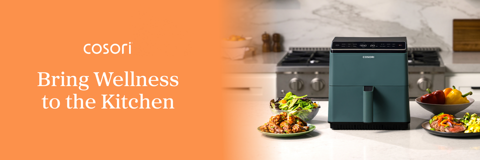 On a banner, text beside an image of a mostly green, boxy air fryer on a counter amid various foods reads, “Cosori. Bring Wellness to the Kitchen.”