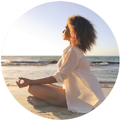 Photo: Woman seated on beach doing yoga.