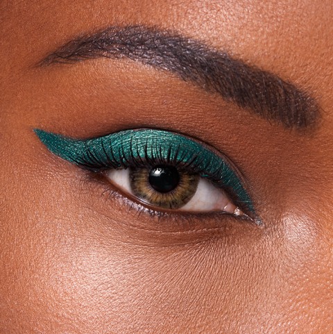 Realistic photograph of black thread, emerald green thread, and gold thread  in a pile on a glass table on Craiyon