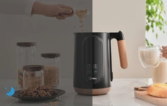 The nut milk maker placed on a dining table, with the image split to show both nighttime and daytime, illustrating the use of a timer feature for convenience.