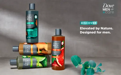 3 bottles stacked on top of each other with a 4th bottle and a piece of eucalyptus nearby.