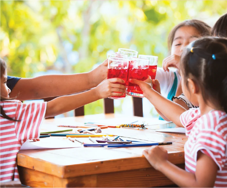 Children drinking Juce outside on a hot summer day.