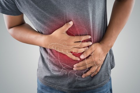 Man holding stomach with red illustrating digestive discomfort