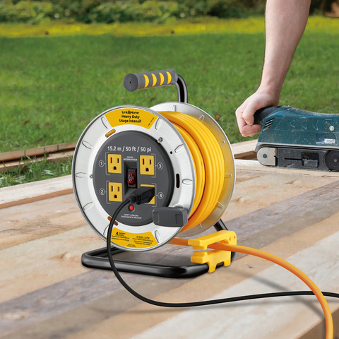 Lifestyle  image of Link2Home 50 Foot Extension Cord Reel being used outdoors with power tool.