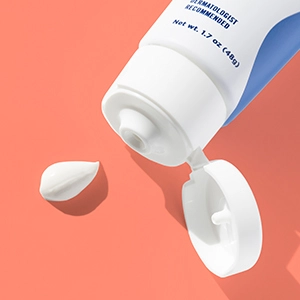 An open tube of Oil Control Moisturizer with a dollop of white cream next to it
