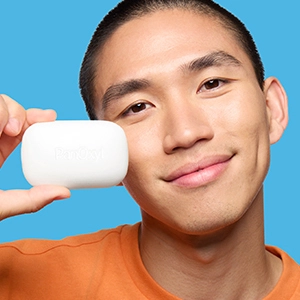 A young man holding Acne Treatment Bar near his face