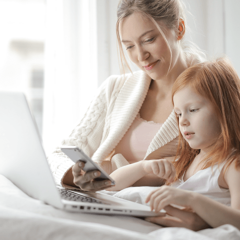 Parental controls – woman and child looking at laptop screen.