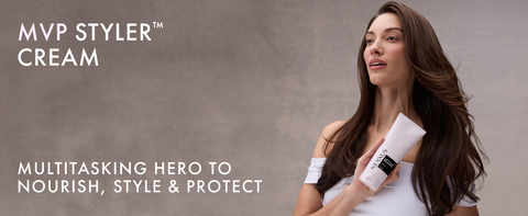 Beige background, woman holding a bottle of Nexxus MVP Styler Cream in her hand.