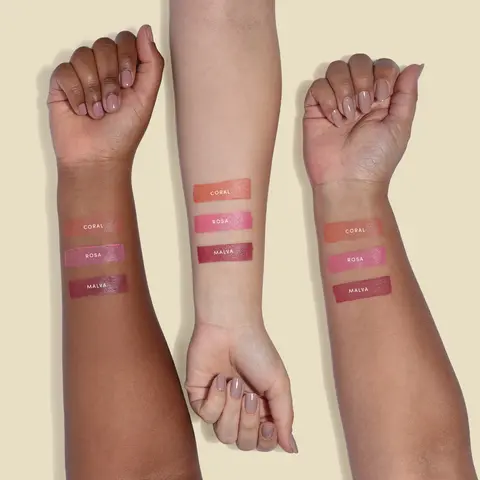 A imagem mostra três braços sob um fundo amarelo claro, demonstrando as tonalidades do blush stick em 3 tons de pele