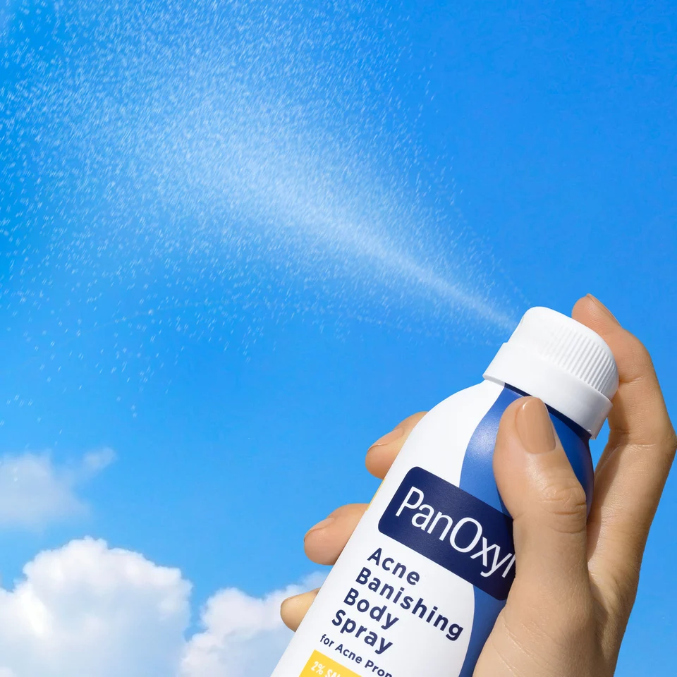 PanOxyl Acne Banishing Body Spray can spraying into the sky to show consistency of product.