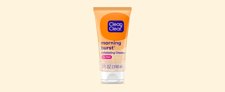 Bottle of Clean & Clear Morning Burst Exfoliating Facial Cleanser on orange background