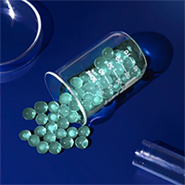 Image of glass container with green caviar spilling out onto deep blue tabletop with beakers nearby.