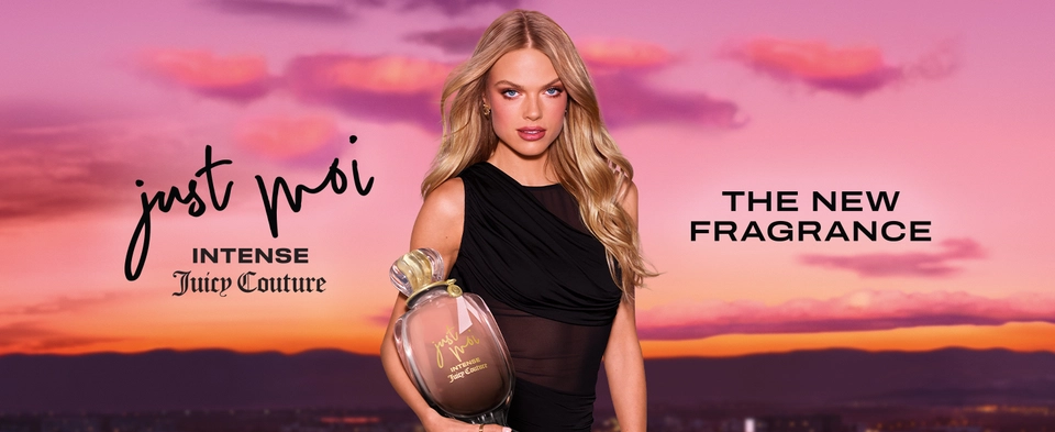 Female model holding Juicy Couture Just Moi Intense perfume bottle with a sunset in background