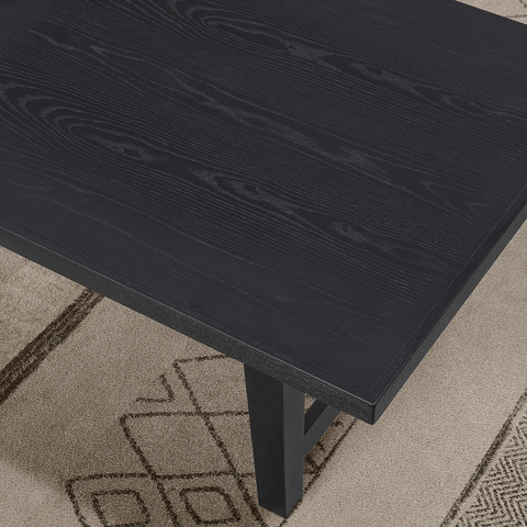 Close-up image of the end of the table, showing the rich textures and black color of the finish