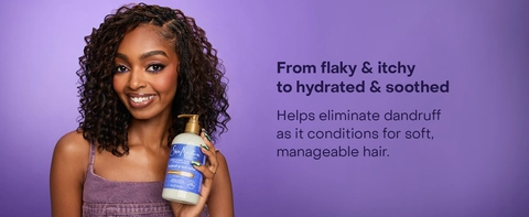 SheaMoisture Dandruff Conditioner held by a woman with curly hair on a purple background. Text reads: "From flaky &amp; itchy to hydrated &amp; soothed. Helps eliminate dandruff as it conditions for soft, manageable hair."