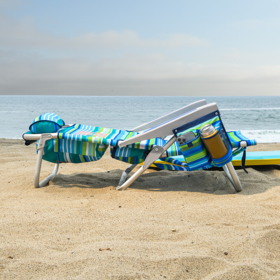 Beach chair lying flat on the beach.