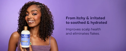 SheaMoisture Dandruff Shampoo held by a woman, wearing a purple top on a purple background. Text reads: "From itchy &amp; irritated to soothed &amp; hydrated. Improves scalp health and eliminates flakes."
