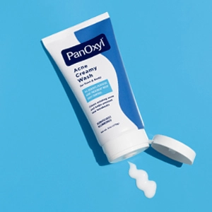An open tube of PanOxyl Acne Creamy Wash with a squiggle of white creamy liquid