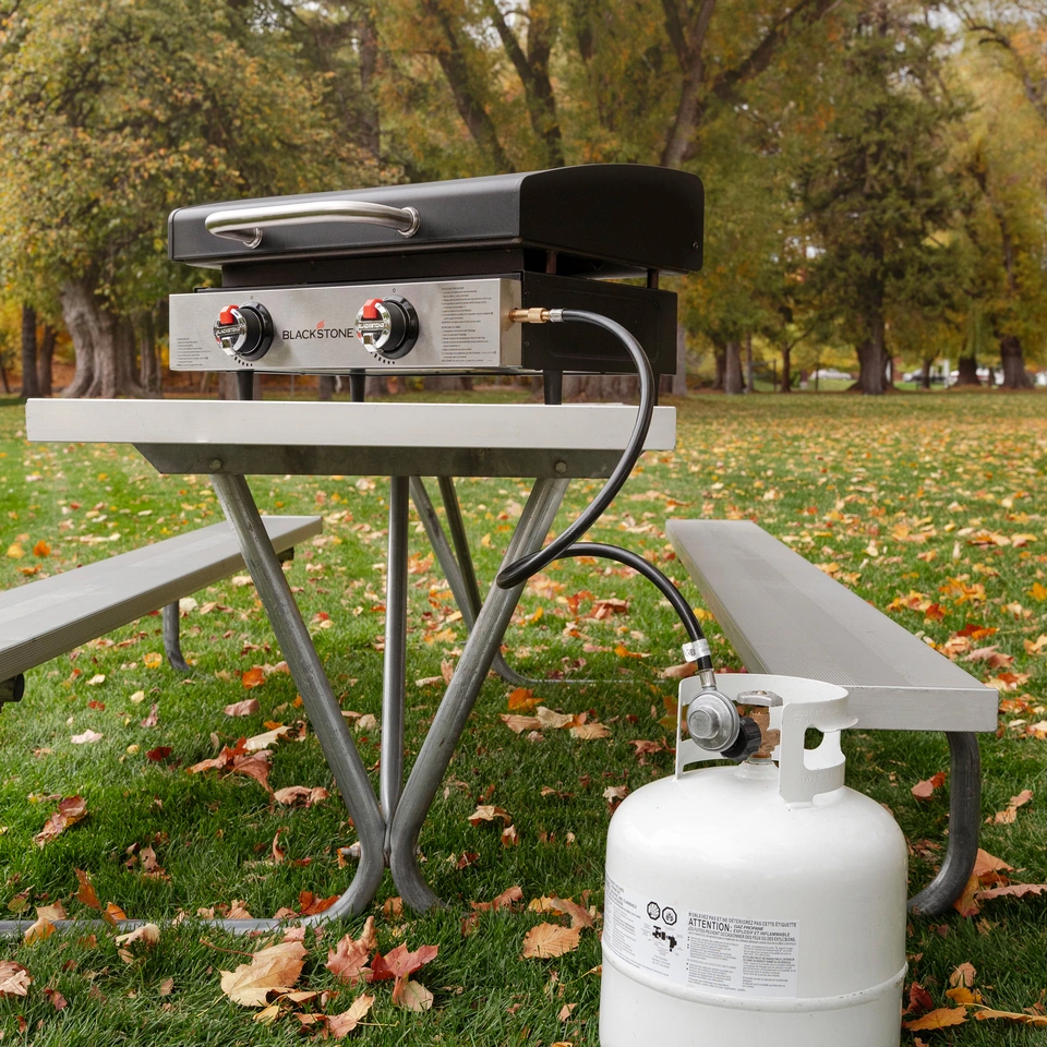Bulk propane adapter hose shown in use with a 20 propane tank and the 22 inch griddle at a park