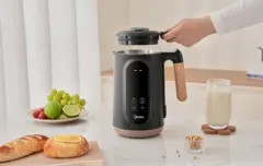 A person lifting the lid of the nut milk maker.