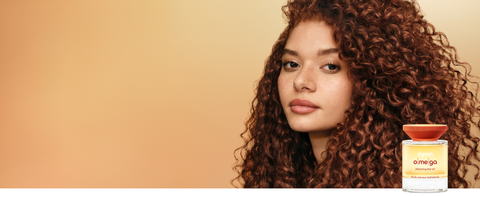 Curly hair model shows off her nourished hair after using Dyson Omega products.