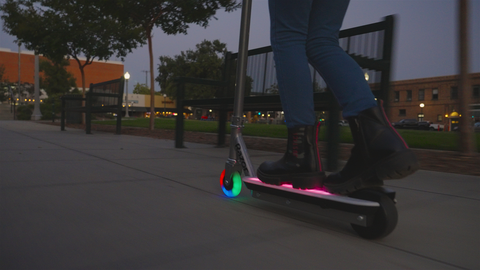 A lighted scooter with a rider on it