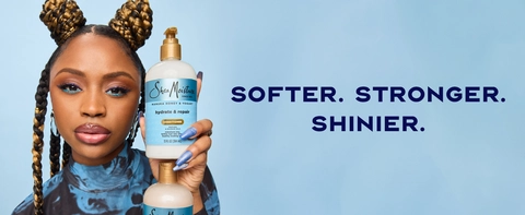 Image of a young black woman with braided hair, holding shampoo and conditioner pump bottles.