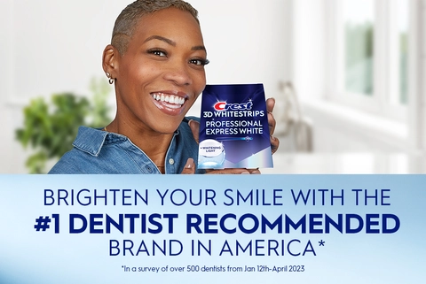 Woman smiling holding Crest 3DWhitestrips Professional Express White + Light pack. Brighten Your Smile with the #1 Dentist Recommended Brand in America.