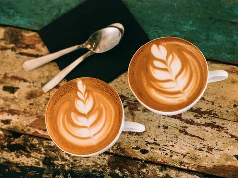 Flat lay overview image of 2 cappuccinos with 2 spoons on a napkin