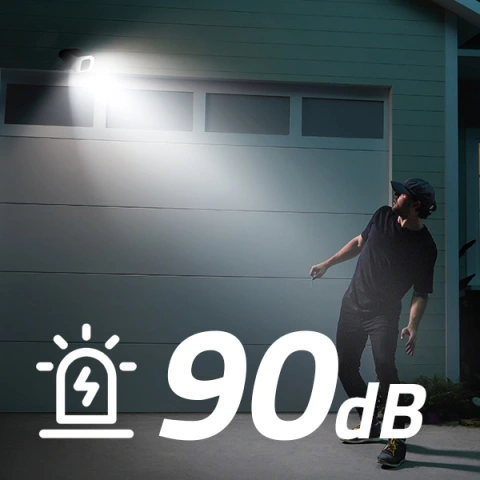 Bright spotlight illuminates unknown stranger outside of home at night with 90 dB alarm stated in text.