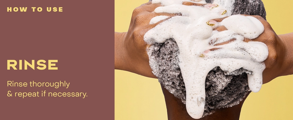 Image of a woman with curly hair rinsing it.