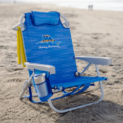 Blue slightly stripped pattern Tommy Bahama branded beach chair with cup in cup holder on the beach. 
