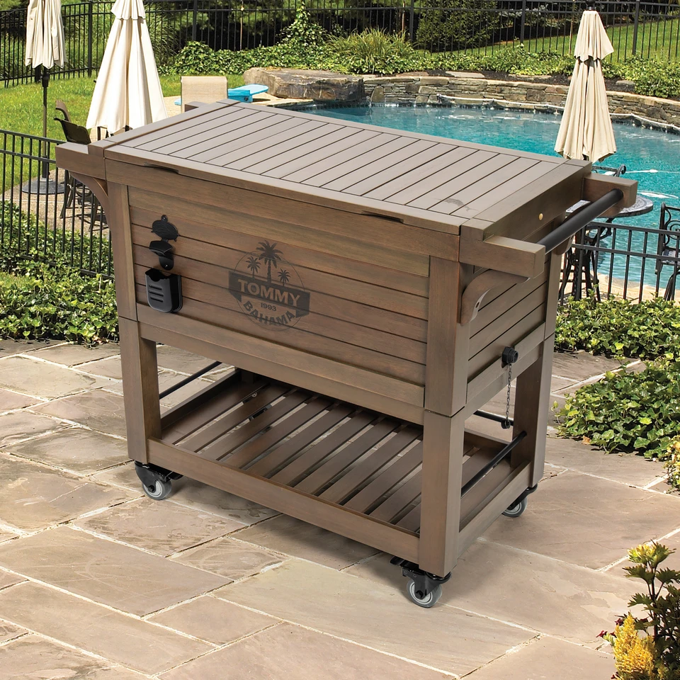 Closed wood cooler on stone patio by a pool.