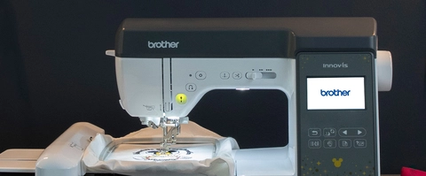 Sewing machine in a dark room, showcasing the LCD display. 