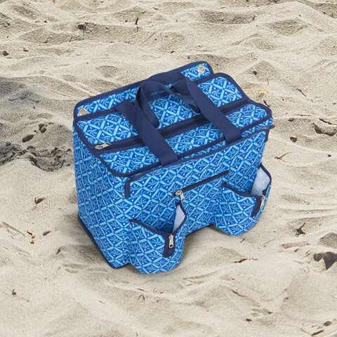 Insulated cooler bag sitting on sand.