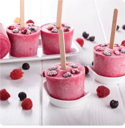 Juce Garden Berry popsicle recipe image showing frozen cup shaped popsicles with fresh frozen berries