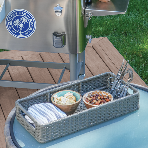 Wicker basket with snack bowls and utensils sitting on glass table.