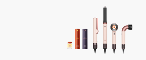 Dyson nourishing and styling beauty collection products in a row next to Dyson styling machines