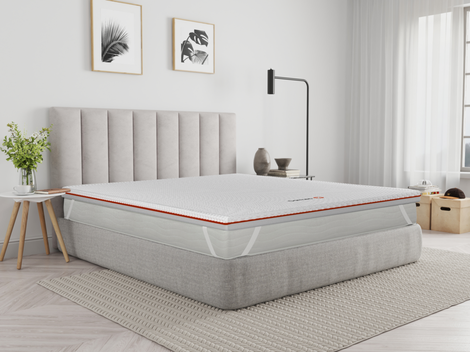 The Premium Mattress Topper on a mattress in a room setting.  Shows the adjustable stay put straps that fit snuggly around the mattress.