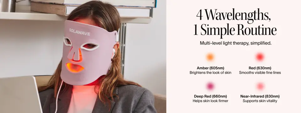 Woman using face light therapy mask with multiple wavelengths for smoother-looking skin and improved tone