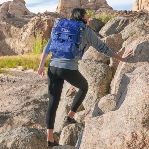 Woman hiking with backpack cooler on her back.