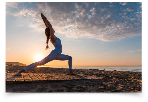 a girl stretches on the beach