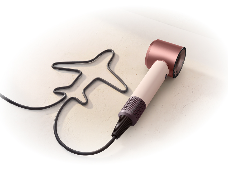 Dyson Supersonic Travel hair dryer with the cable shaped to resemble an airplane.