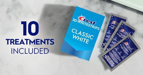 10 Treatments Included. Pack of Crest 3DWhitestrips Classic White next to 3 sachets on a marble counter.