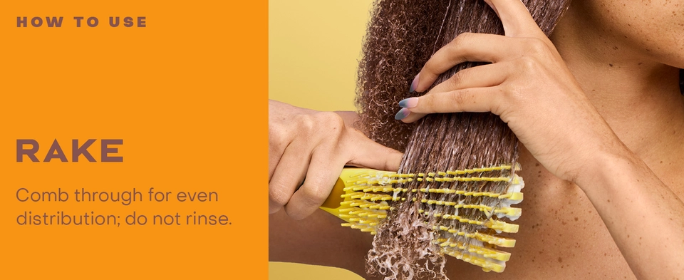 Image of a woman detangling her hair with product.