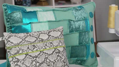 2 pillows, large pillow teal patchwork pillow with piping decorative stitch, and faux gray snake skin pillow with neon green piping stitches.