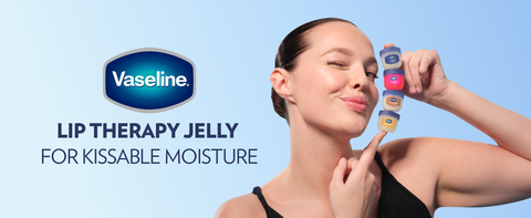 Image of a woman holding 4 small pots of Vaseline Lip Therapy Jelly, each of one kind.