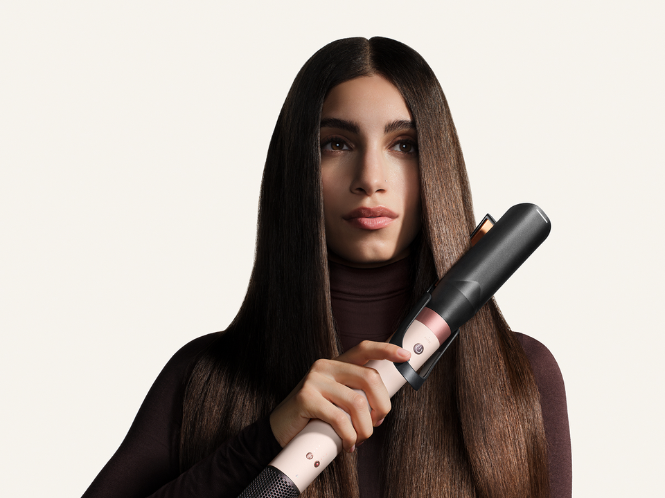Model straightens her hair with the Dyson Air straightener 2x attachment.