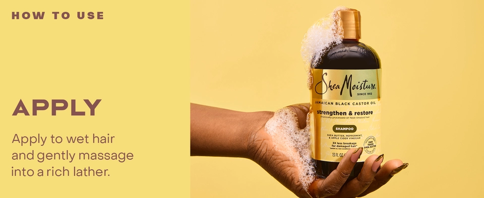 Image of hands holding a shampoo bottle with product.