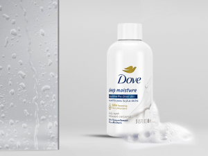 Dove body wash bottle with water droplets on a bathroom glass surface and a soft gray background.